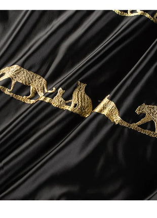 a black and gold fabric with animals on it