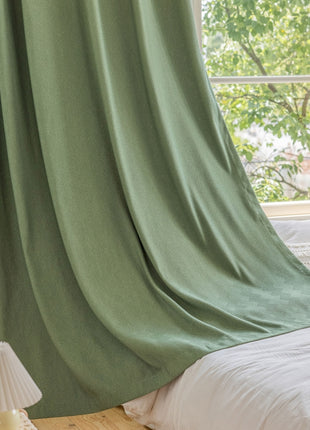 a bedroom with a green drapes and a white bed