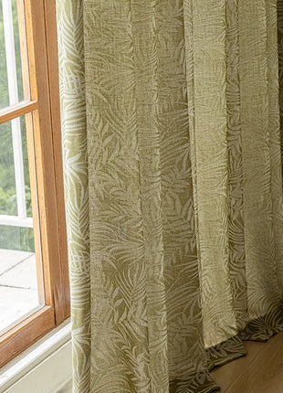 a window with a curtain and a chair in front of it