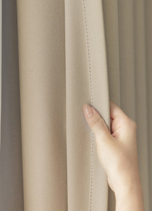 a person's hand on the curtain of a window