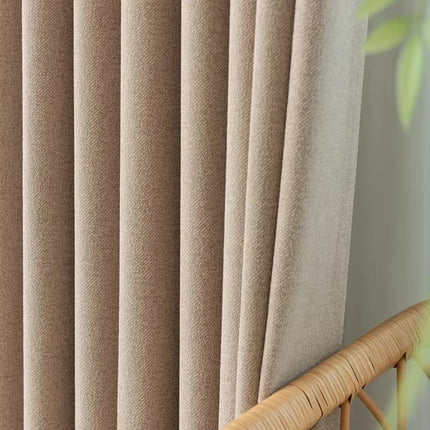 a close up of a curtain with a plant in the background