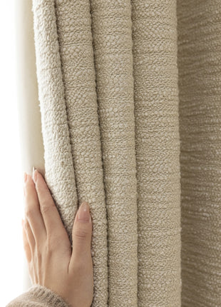 a person is holding a curtain with their hand