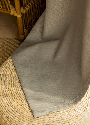 a person standing on a rug next to a wicker chair