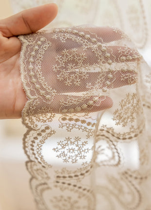 a person holding a piece of lace in their hand