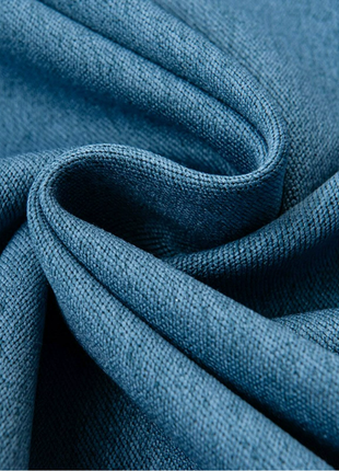 a close-up view of a blue fabric, possibly a piece of clothing or textile, with a textured and wrinkled appearance.