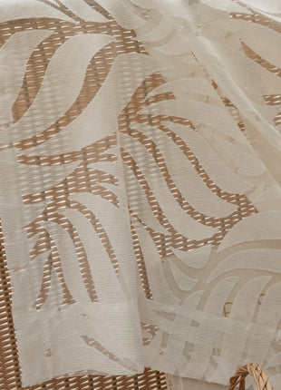 a basket sitting on top of a bed next to a white curtain