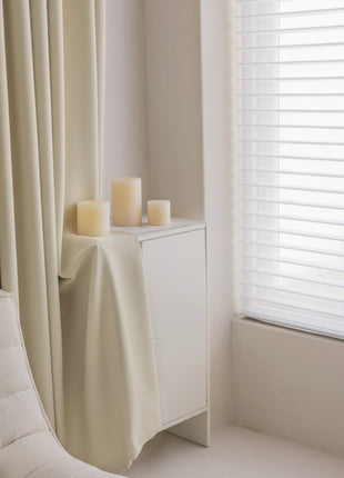 a white cabinet with candles on it next to a window