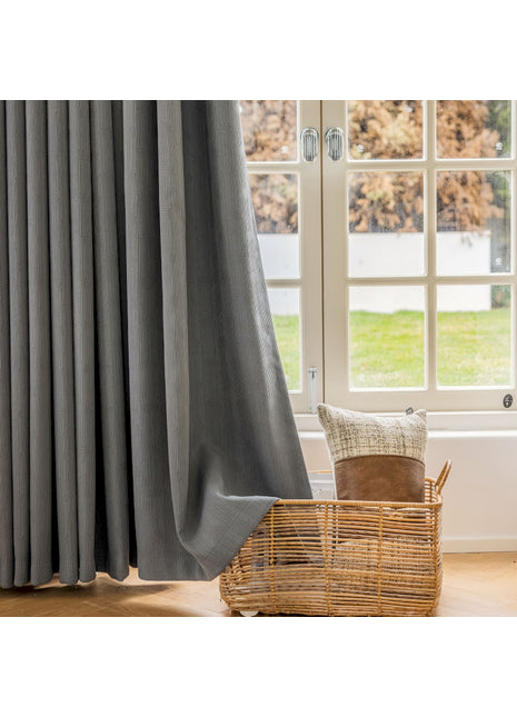 a chair and a basket in front of a window