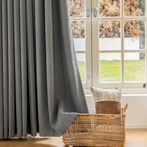 a chair and a basket in front of a window