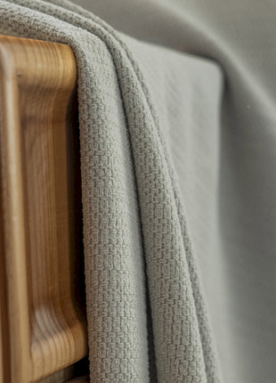 a close up of a bed with a wooden headboard
