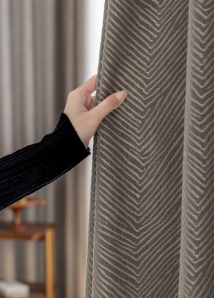 a woman is opening a curtain with her hand