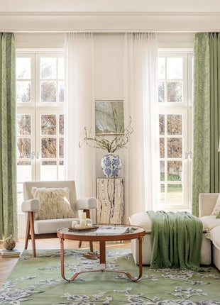 a living room filled with furniture and green curtains