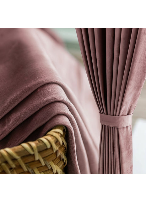 Rideau en velours rose poudré drapé près d'un panier en osier
