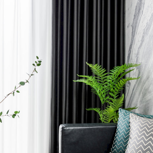 a green plant sitting on top of a black chair