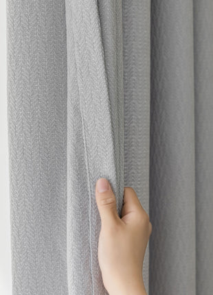 a hand that is holding a curtain in front of a window