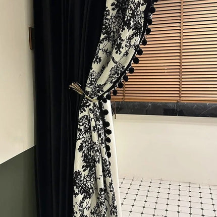 a black and white curtain with pom pom trim