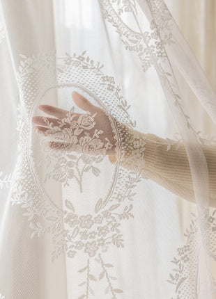 a woman's hand is seen through a sheer curtain