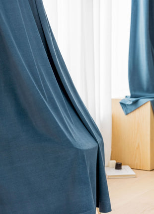 a room with a blue curtain and a wooden floor