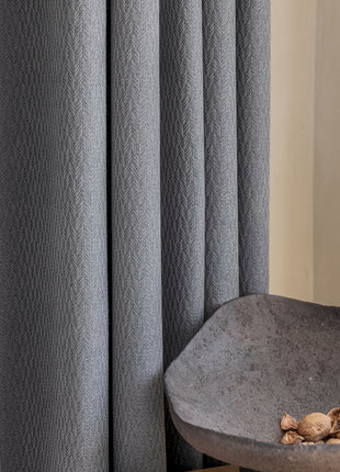 a bowl of nuts sitting on a table next to a curtain