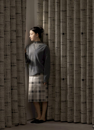 a woman standing in front of a curtain
