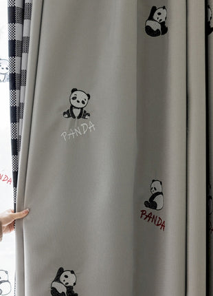a person standing next to a curtain with panda stickers on it