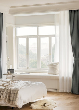 a bedroom with a large window and a white bed