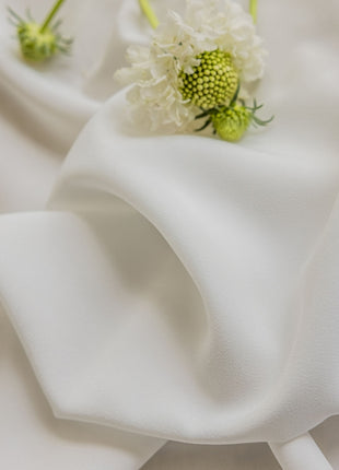 a close up of a flower on a white cloth