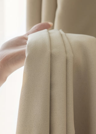 a person holding a curtain with their hand