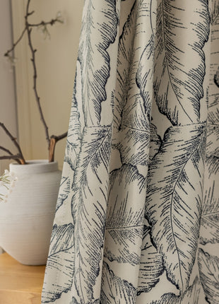 a close up of a curtain with a plant in the background