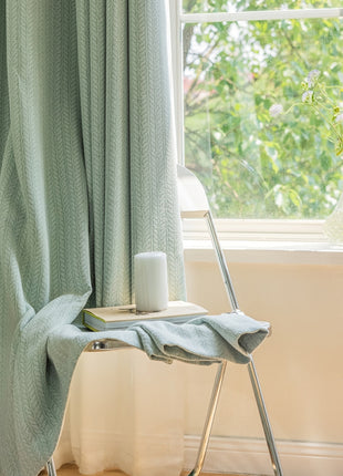 a chair with a towel on it next to a window
