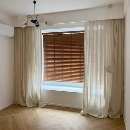 an empty room with a window and a curtain