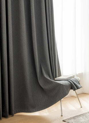 a chair sitting in front of a window next to a curtain