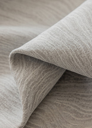 a close up of a bed with a gray blanket