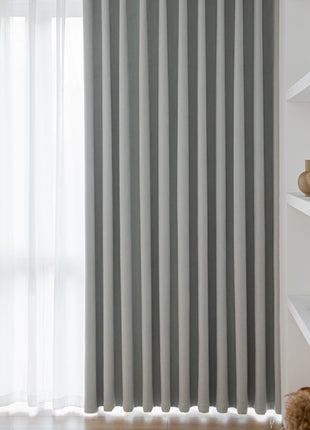 a window with a gray striped curtain in front of it