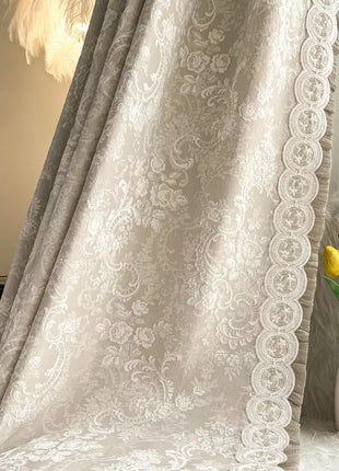 a vase with yellow flowers sitting next to a curtain