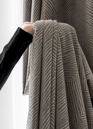 a person is holding a piece of cloth in front of a window