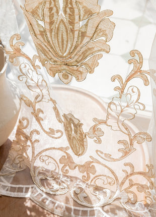 a close up of a sheer curtain near a potted plant