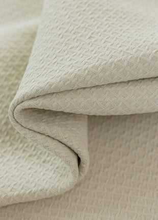 a close up of a white blanket on a bed