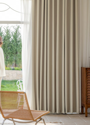 a woman standing in a living room next to a window