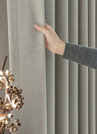 a person is holding a curtain in front of a window