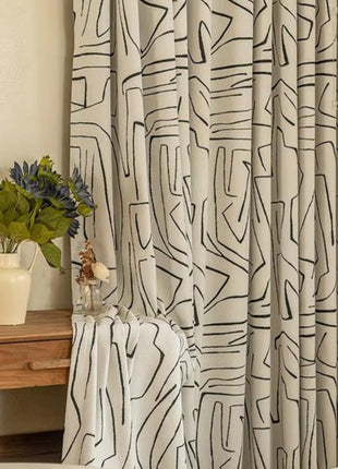 a white bed sitting next to a window covered in curtains