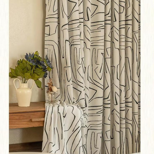 a white bed sitting next to a window covered in curtains
