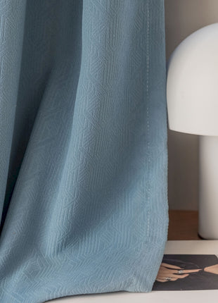 a white lamp sitting next to a blue curtain