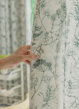 a person holding a curtain with a flower pattern on it