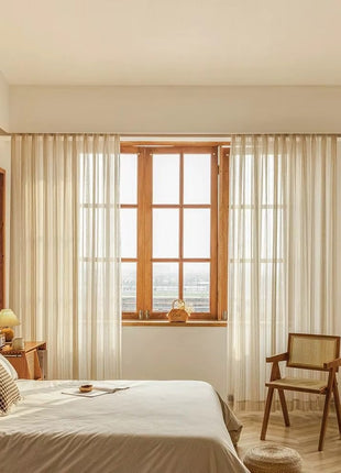 a bedroom with a bed, chair, and window