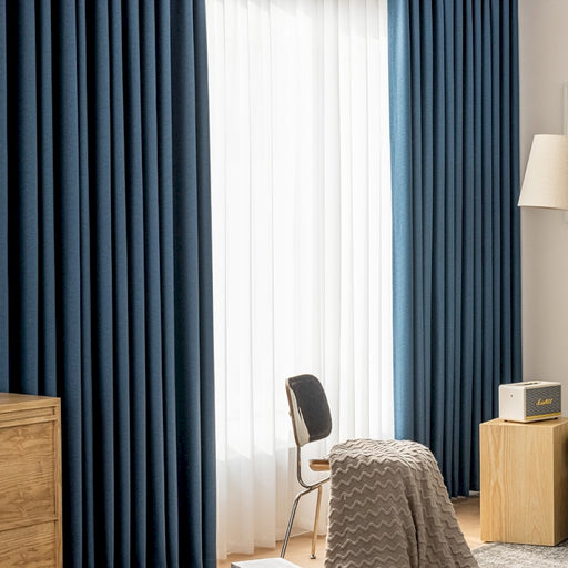 a bedroom with blue curtains and a bed