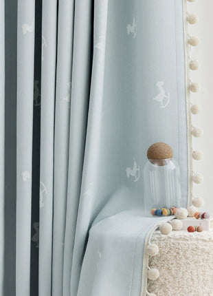 a white bed sitting next to a window covered in curtains