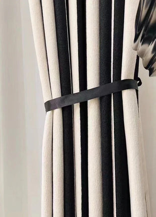 a black and white curtain with a black ribbon