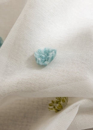 a close up of a white fabric with blue flowers on it