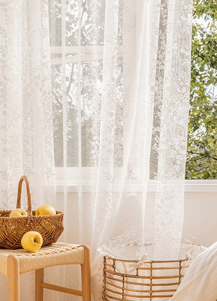 a basket of apples sitting on a table next to a window